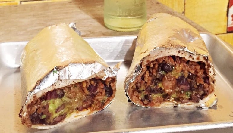 burrito cut in half resting on a silver tray