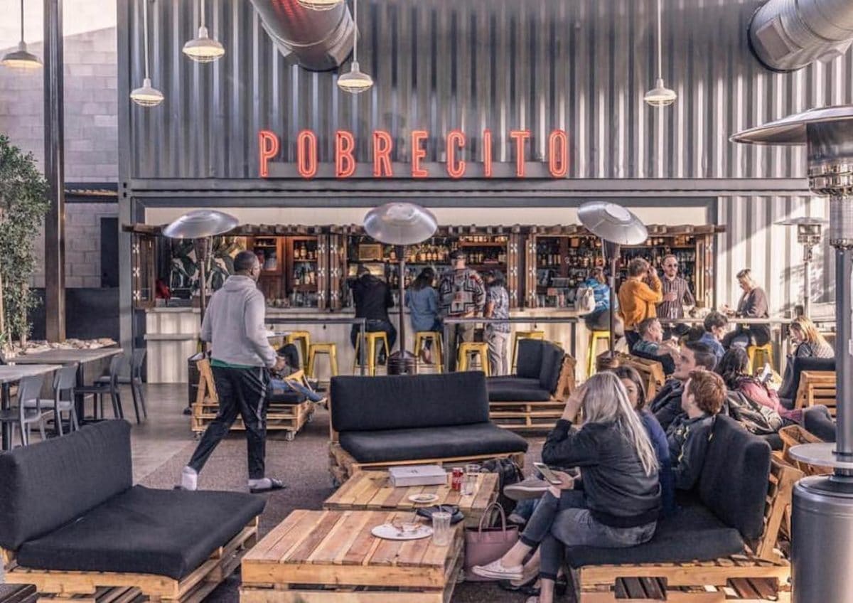 people sitting outside with bar in background