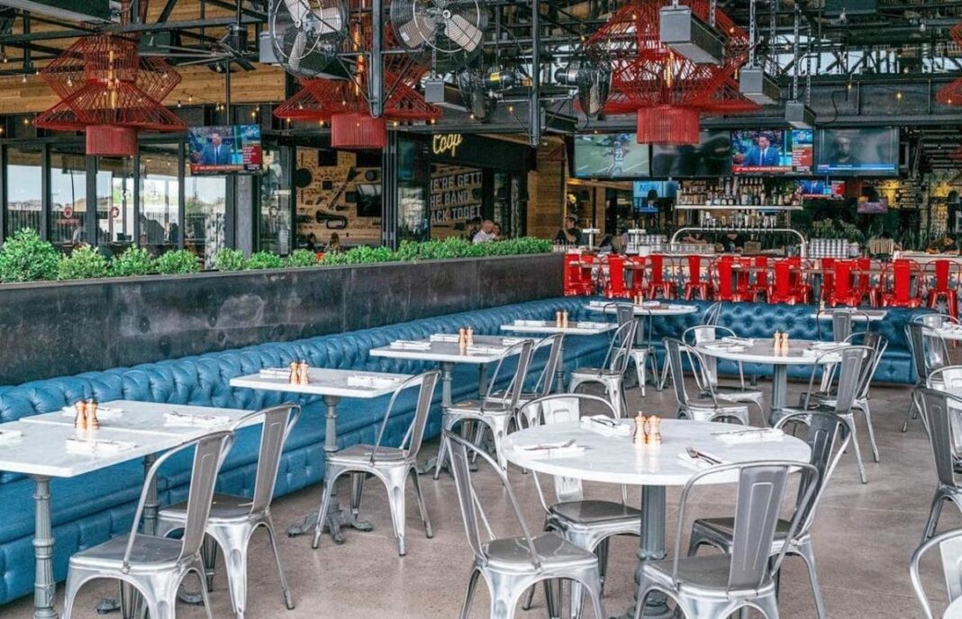 empty bar restaurant with silver tables, chairs, and blue couch
