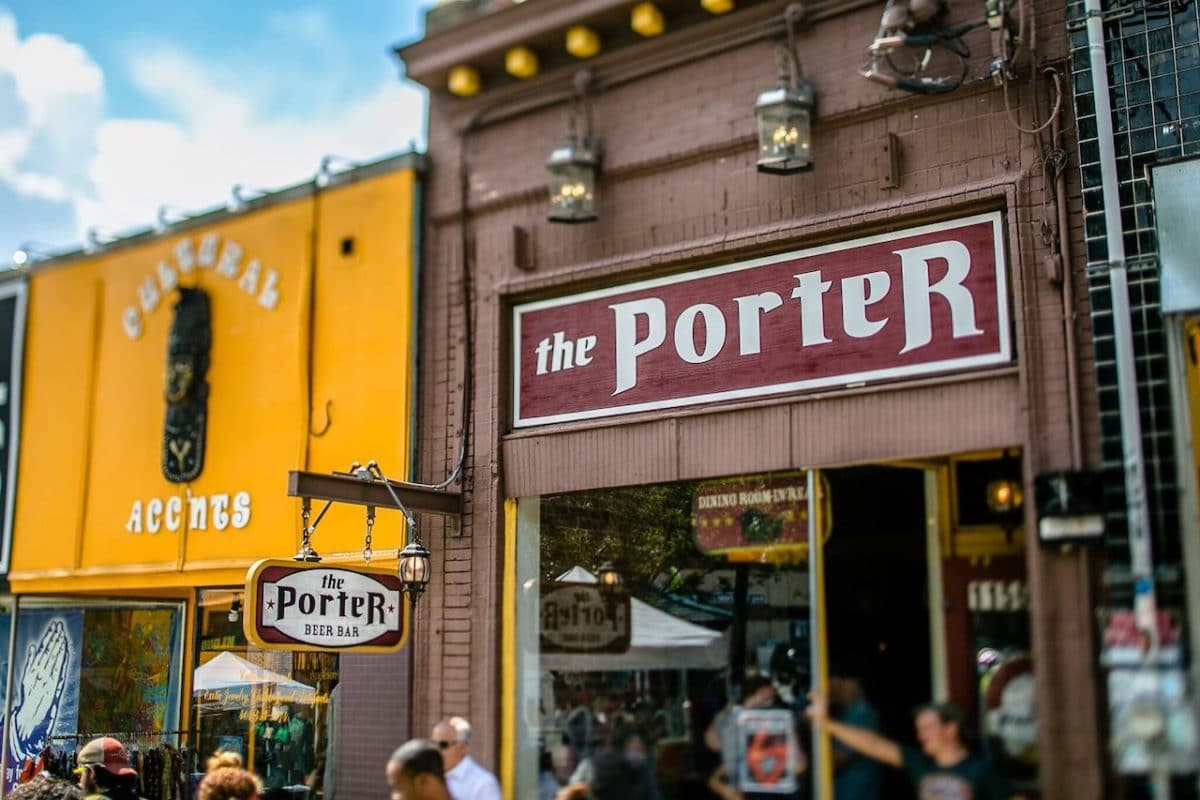 exterior of porter beer bar with sign and people drinking at tables outside