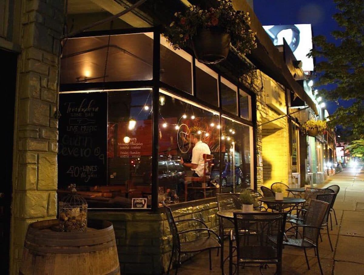 exterior of wine bar with table and chairs on outdoor patio at night