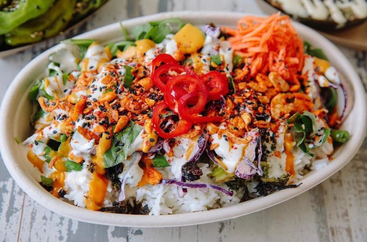 rice bowl with colorful veggies and sauce on it