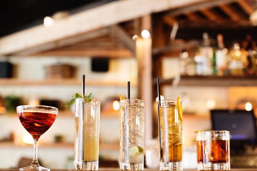 drinks sitting on bar top with larger eating and drinking space in background