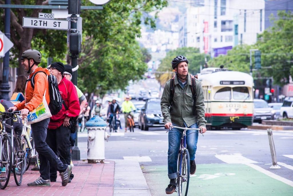 man on bike in bike lane looking around downtown SF