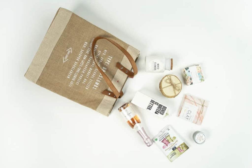 brown bag with shopping finds pouring out of it on white background