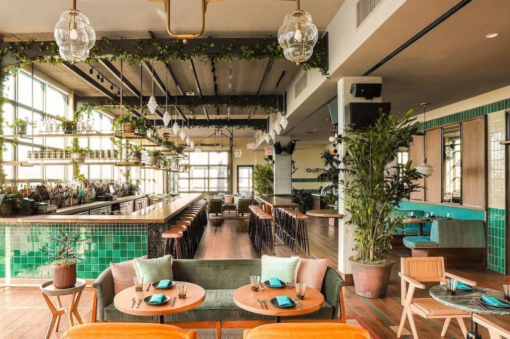 interior of restaurant with leafy trees and bright colors