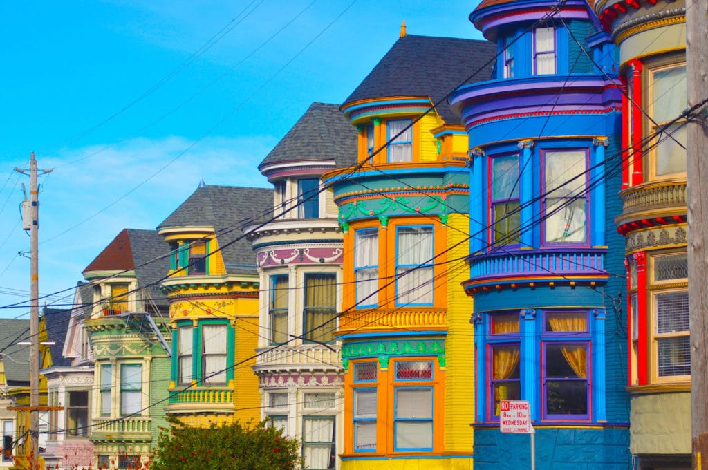 colorful houses lined up in a row with blue sky in background
