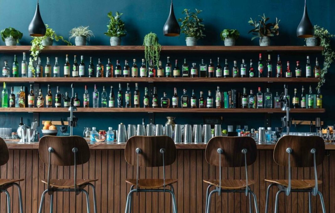 wall of liquor with empty bar stools in front of bar