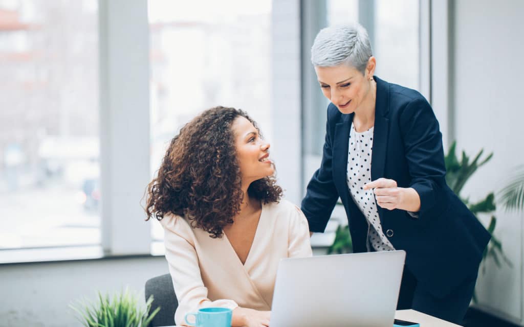 property manager speaking to leasing agent with her laptop open