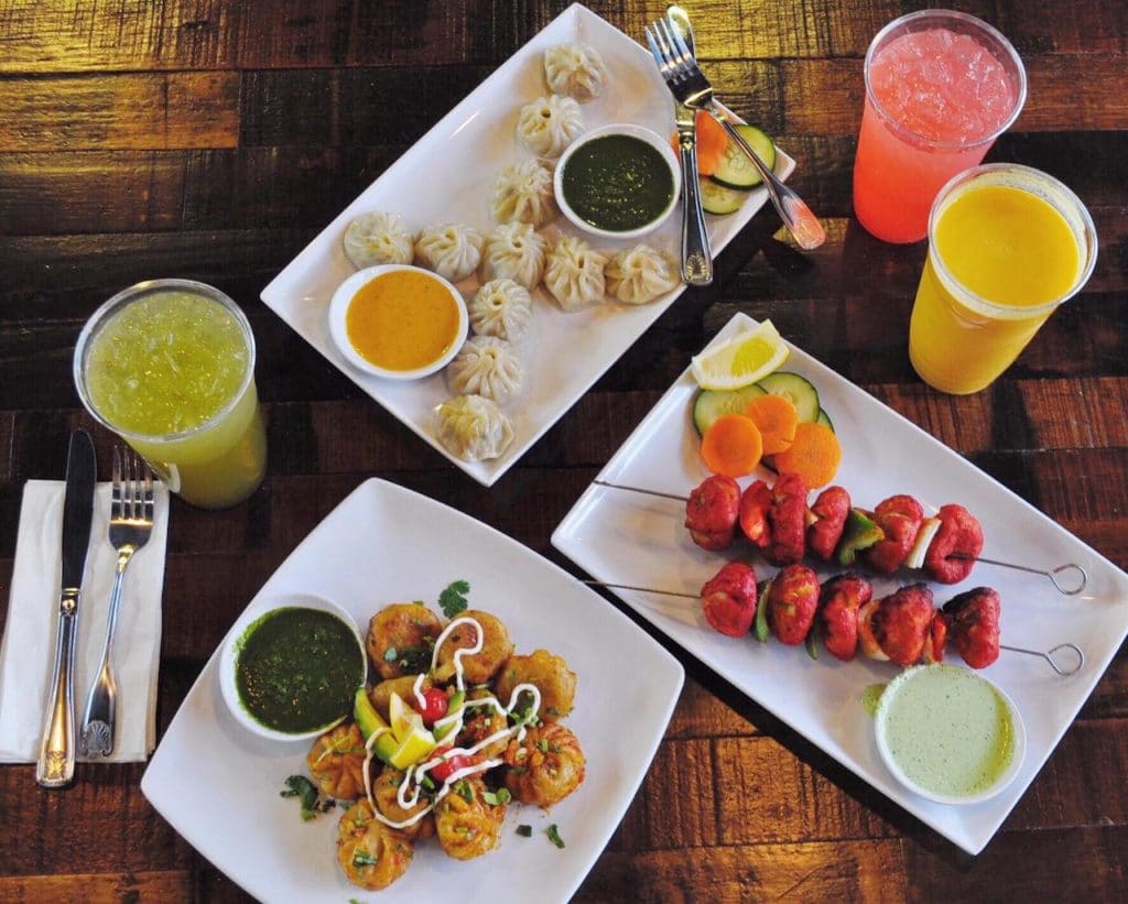 aerial shot of table with white plates with food and drinks on it