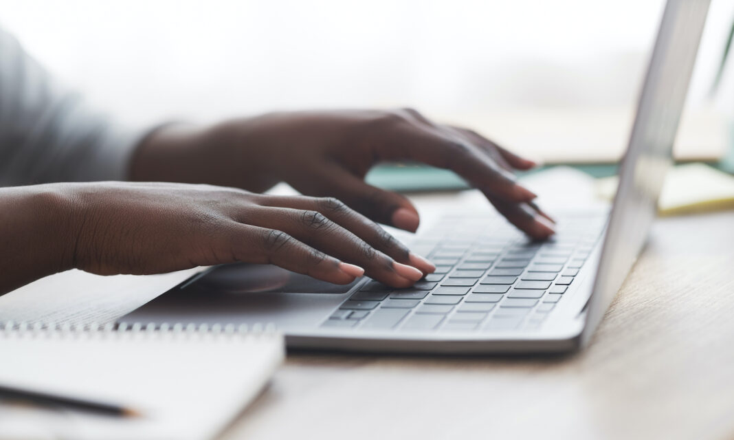 hands typing on the keyboard of a laptop