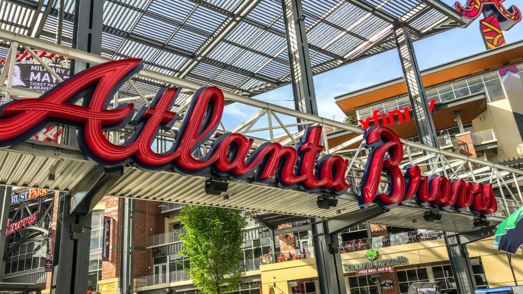 Truist Park is home to the Atlanta Braves. People mill about outside the park, waiting for the game to start.