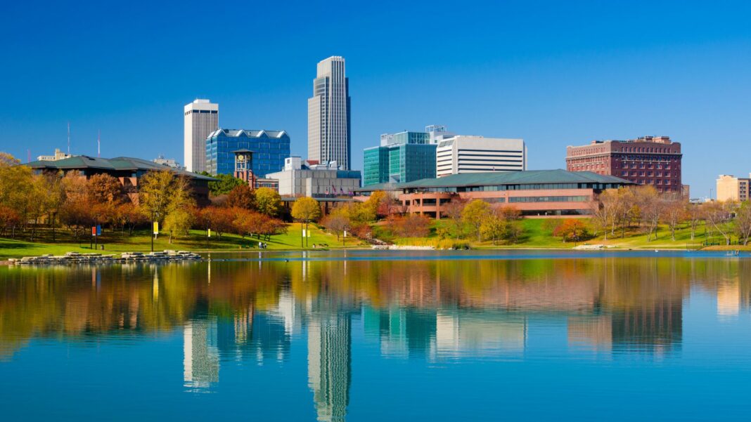 Omaha downtown skyline during Autumn, with a lake at the Heartland of America Park in the foreground