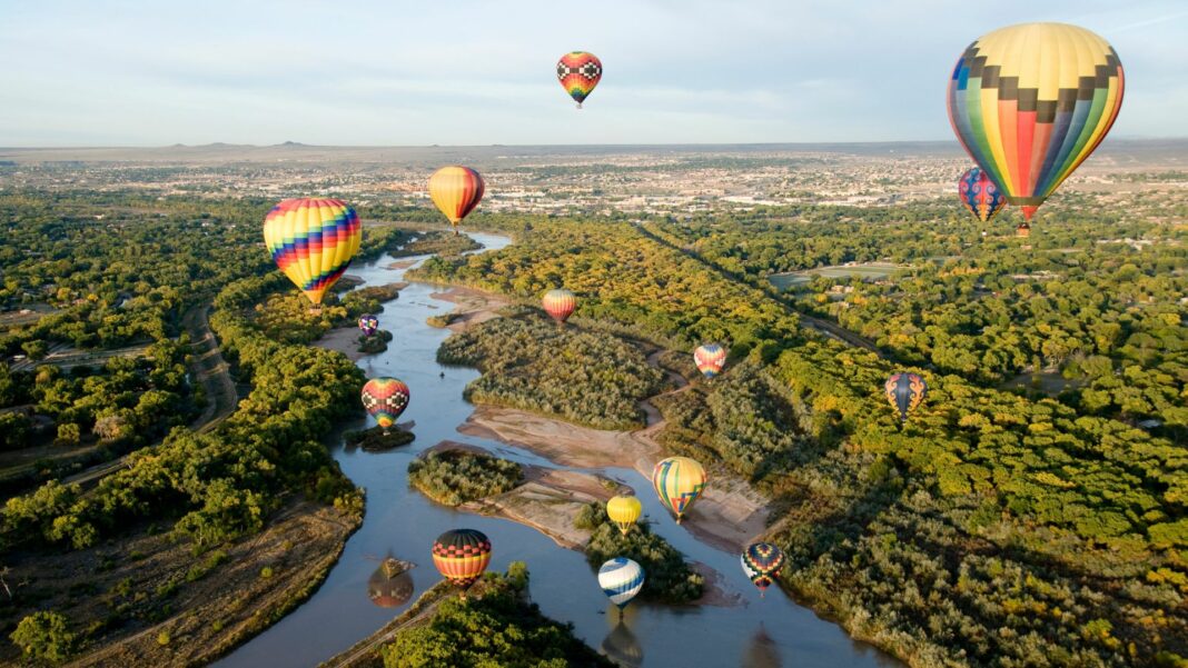 Hot air balloons drifting over the Rio Grande river in Albuquerque, New Mexico.