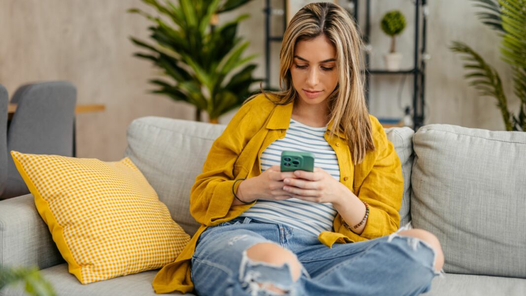 Young woman using her smartphone indoors