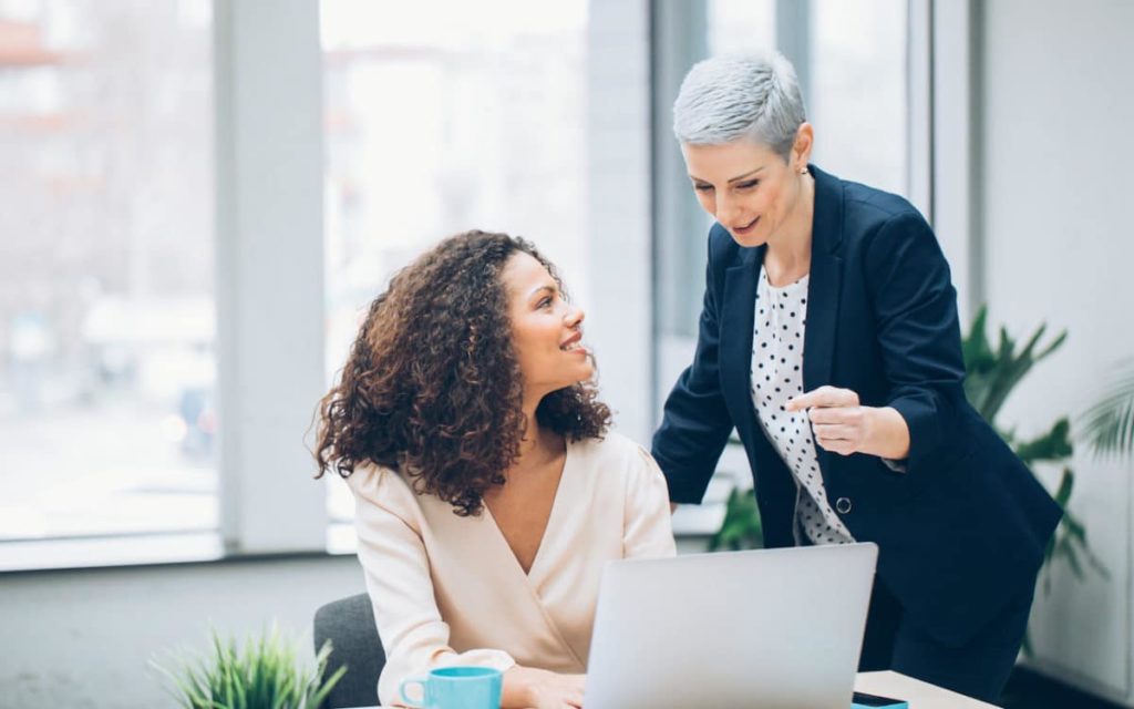 property manager speaking to leasing agent with her laptop open