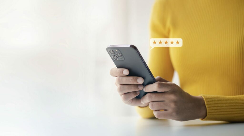 Image showing woman holding phone leaving a review online.